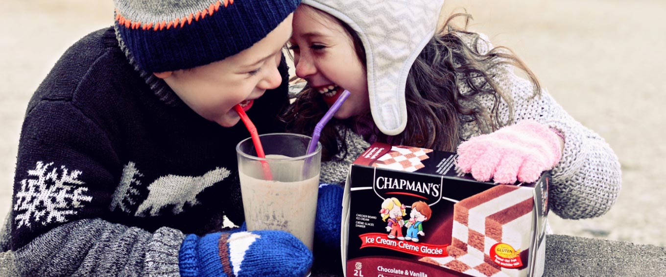 Boy and girl smiling and enjoying a milkshake made with Chapman's Chocolate & Vanilla Checkerboard Ice Cream