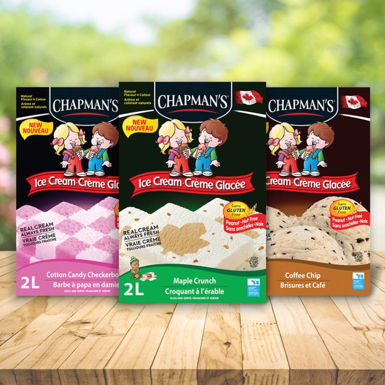 Three of Chapman's Original Ice Cream boxes sitting on a wooden table, left to right: Cotton Candy Checkerboard, Maple Crunch and Coffee Chip