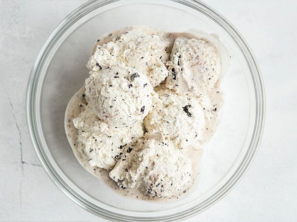 Boules de crème glacée à la Biscuits et crème légèrement fondues dans un bol à mélanger.