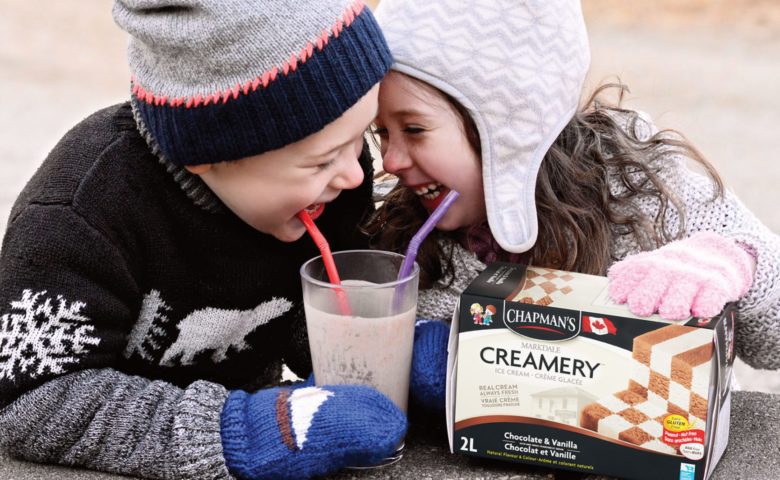 Boy and girl smiling and enjoying a milkshake made with Chapman's Chocolate & Vanilla Checkerboard Ice Cream