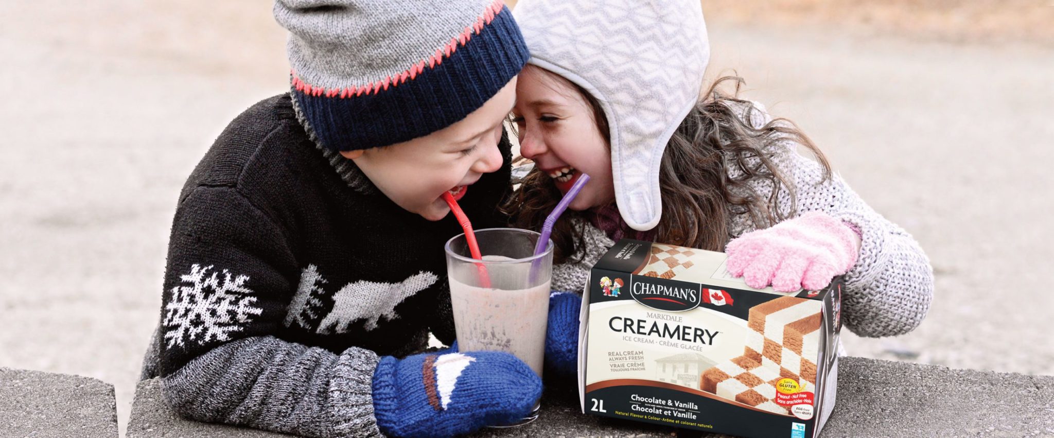 Boy and girl smiling and enjoying a milkshake made with Chapman's Chocolate & Vanilla Checkerboard Ice Cream