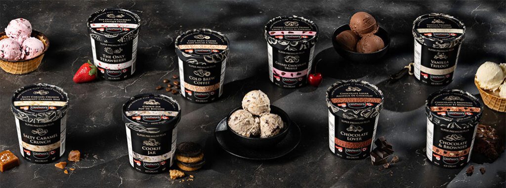 On a dark grey counter top, evenly spaced out, are eight tubs of Chapman's Super Premium Plus ice cream. Spaced throughout the tubs there are three bowls full of ice cream.