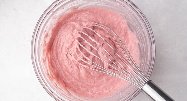 After mixing the ingredients in the glass bowl there is a pink batter