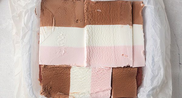 The thin layers of Neapolitan Ice Cream are spread on top of the cooked cake batter
