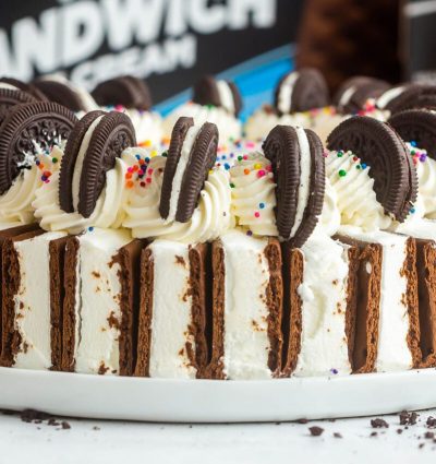 Picture of our ultimate ice cream cake with sandwiches on and cookies on the outside